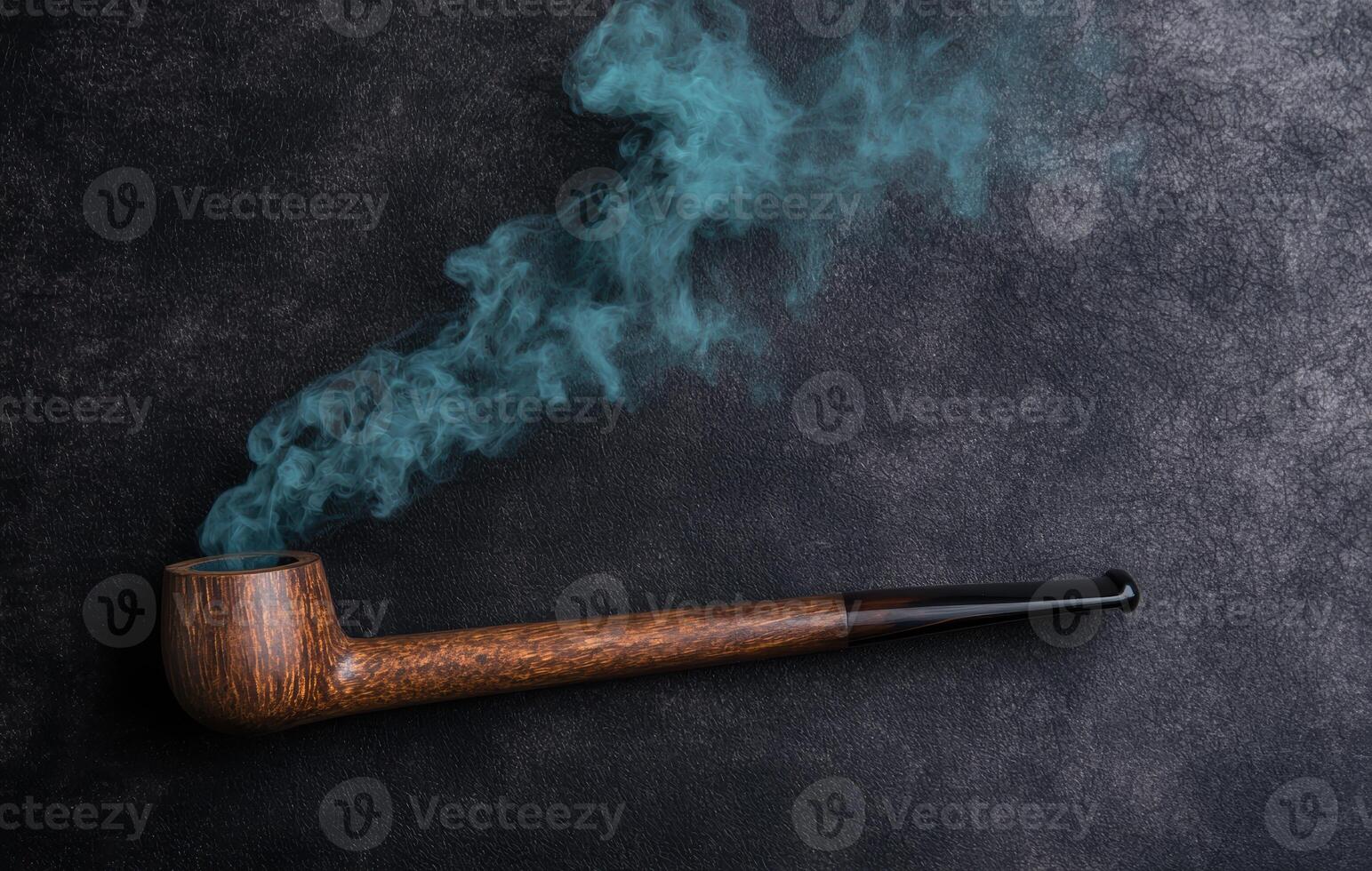 Wooden smoking pipe with blue smoke photo
