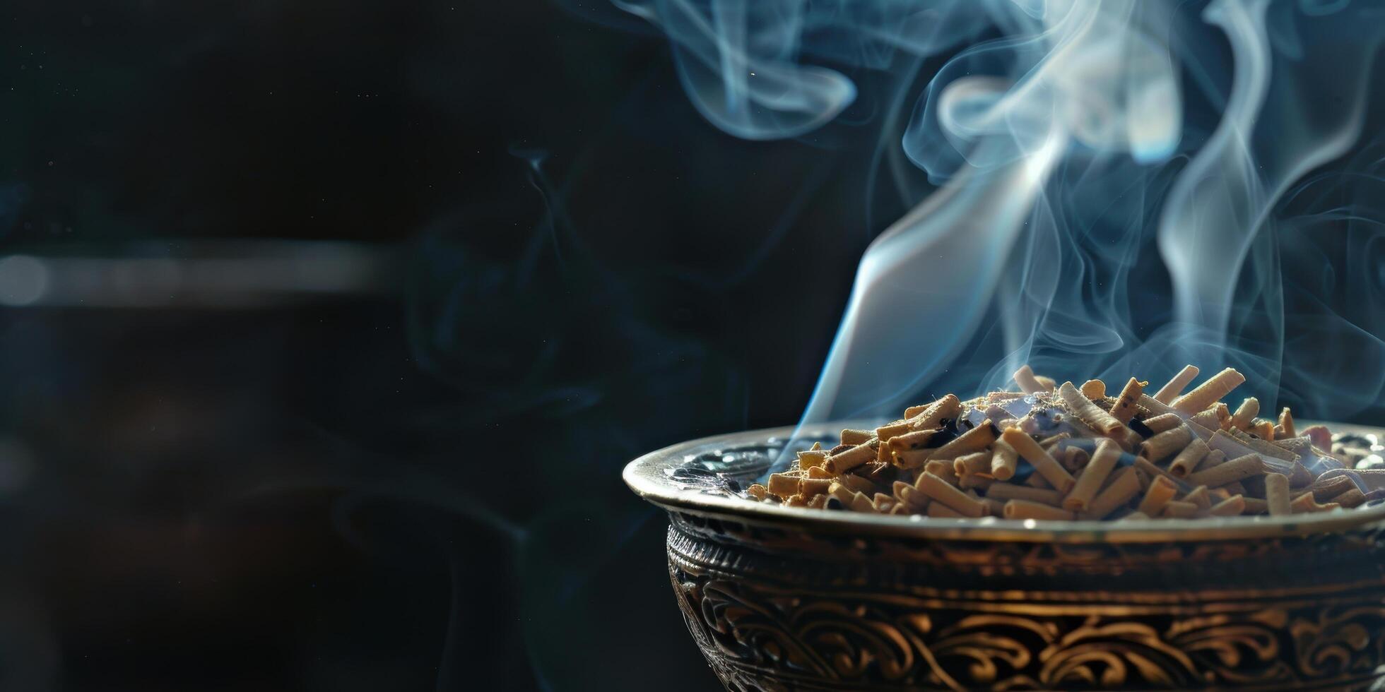 Smoldering incense sticks in ornate bowl photo