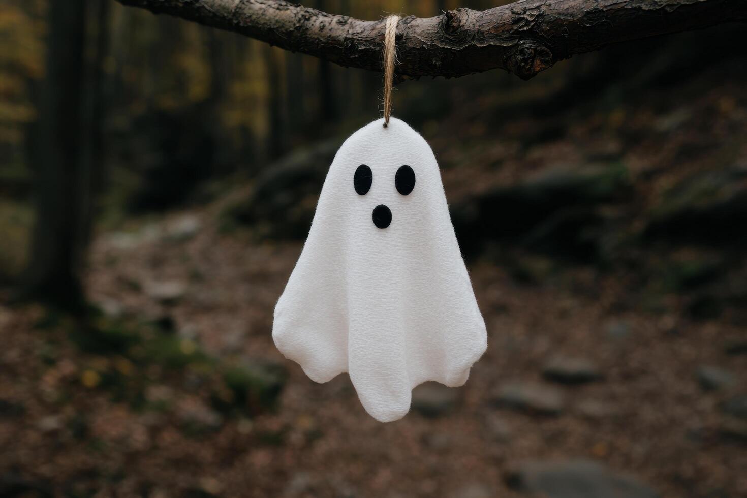 Spooky ghost hanging from tree branch photo