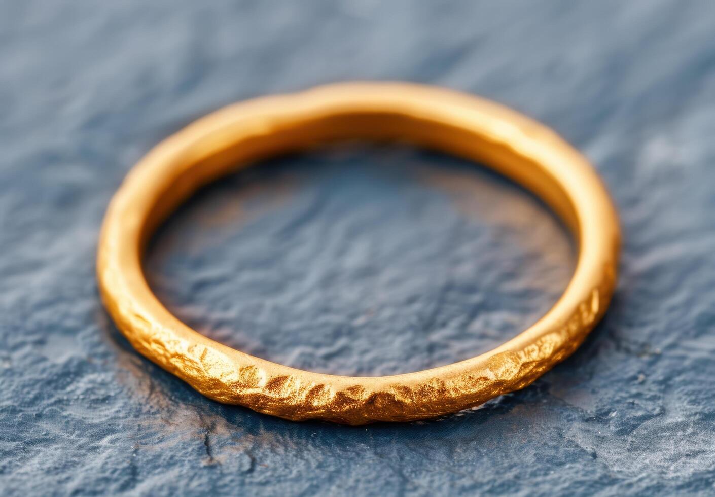Textured gold ring on a dark background photo
