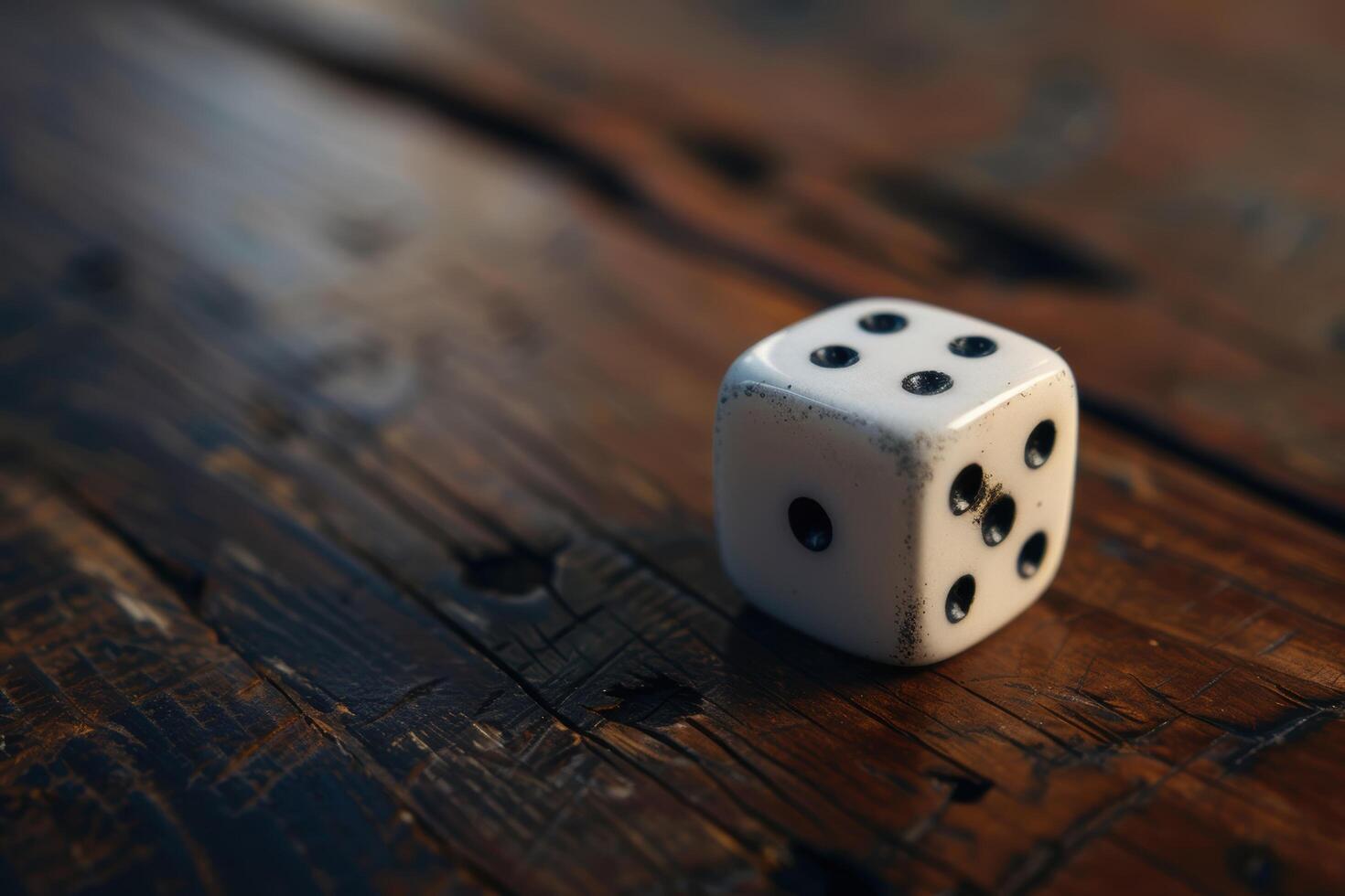 Vintage wooden table with a single white dice photo