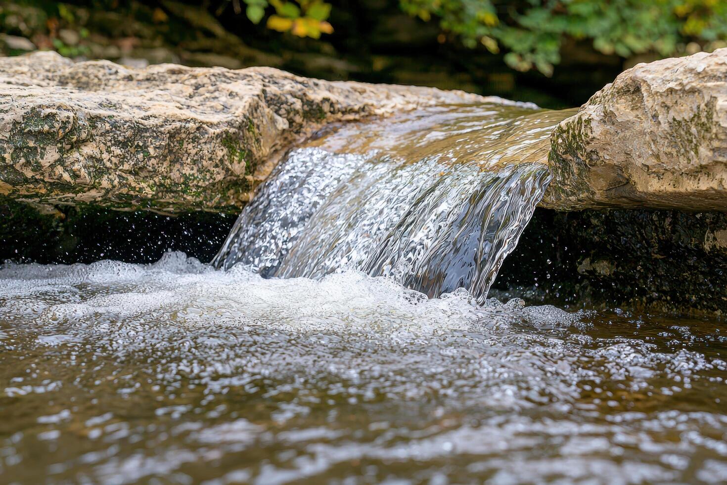Flowing water cascades over rocks in a natural setting photo