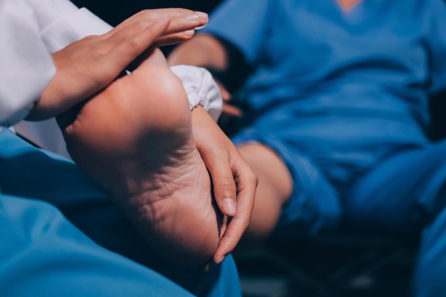 Physiotherapist nurse doing physiotherapy to rehabilitate leg of elderly female patient. photo
