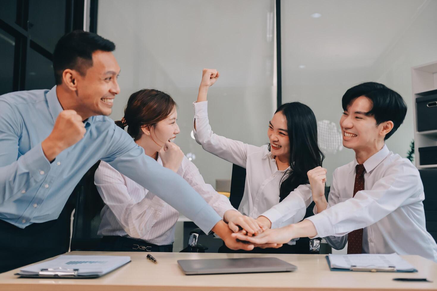 Group of business workers standing with hands together at the office photo