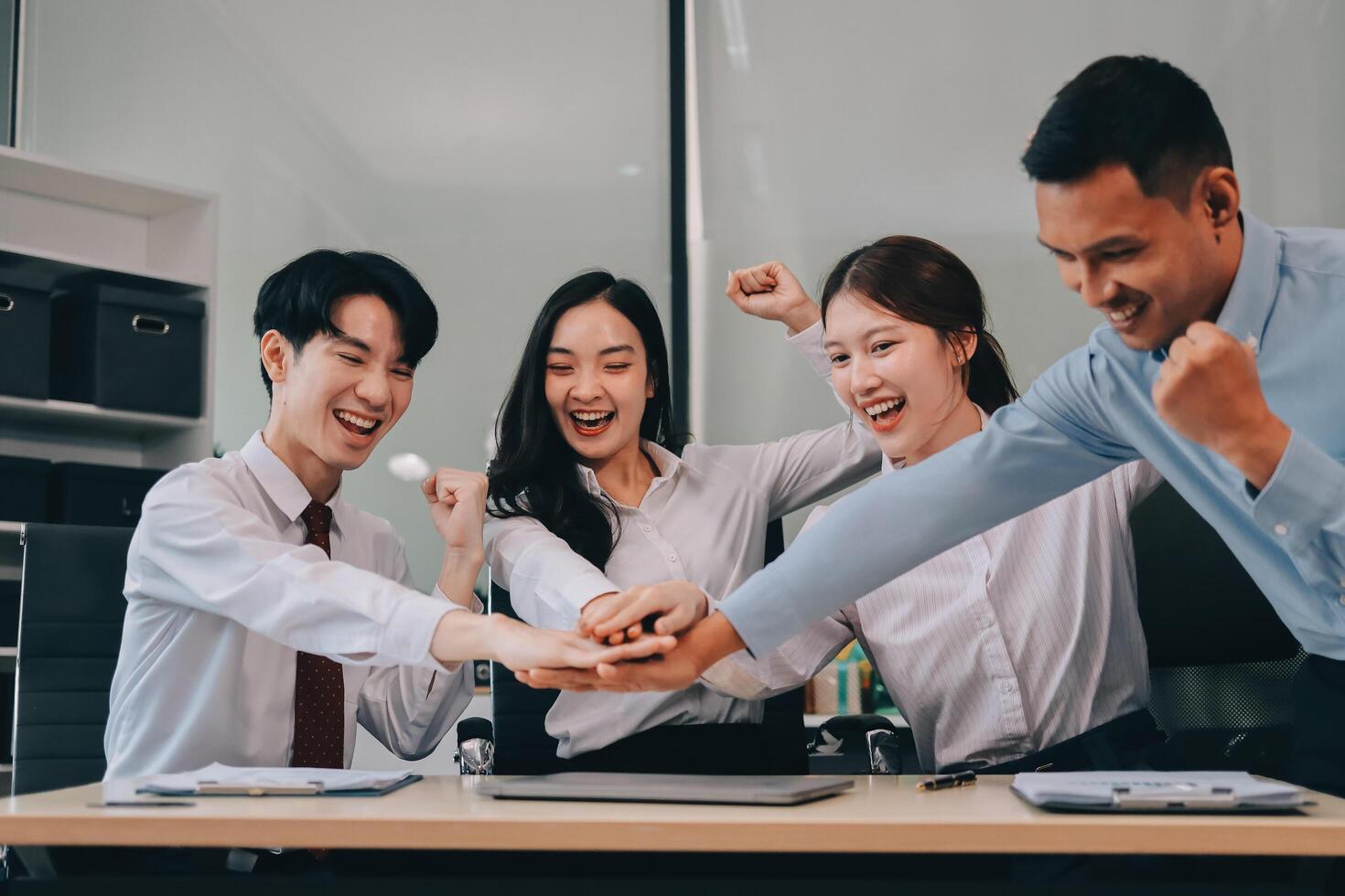 Group of business workers standing with hands together at the office photo