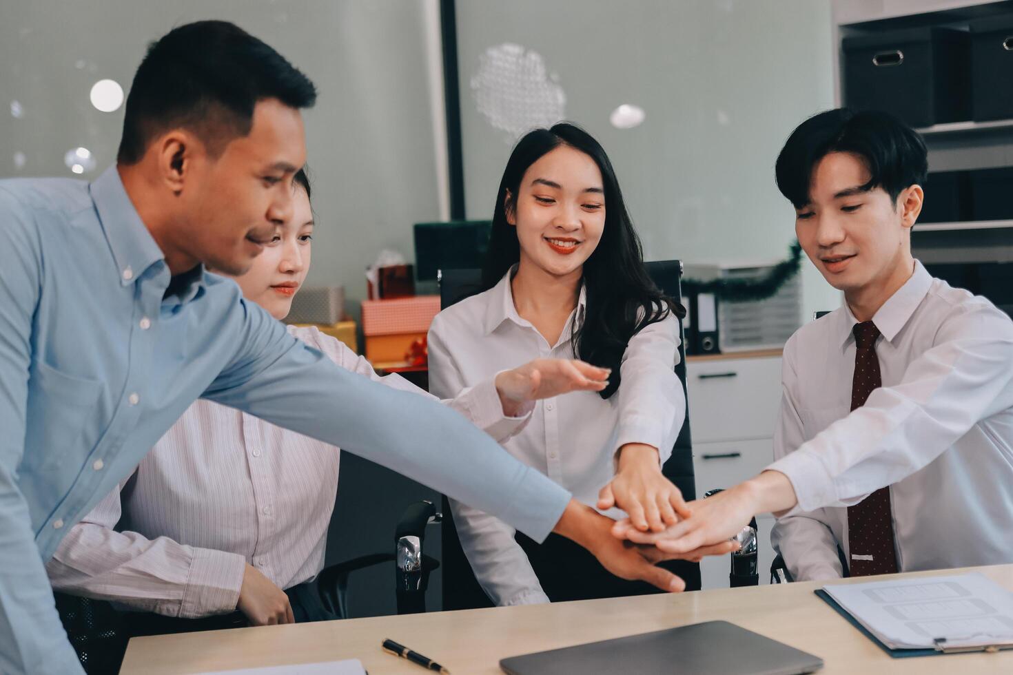 Group of business workers standing with hands together at the office photo