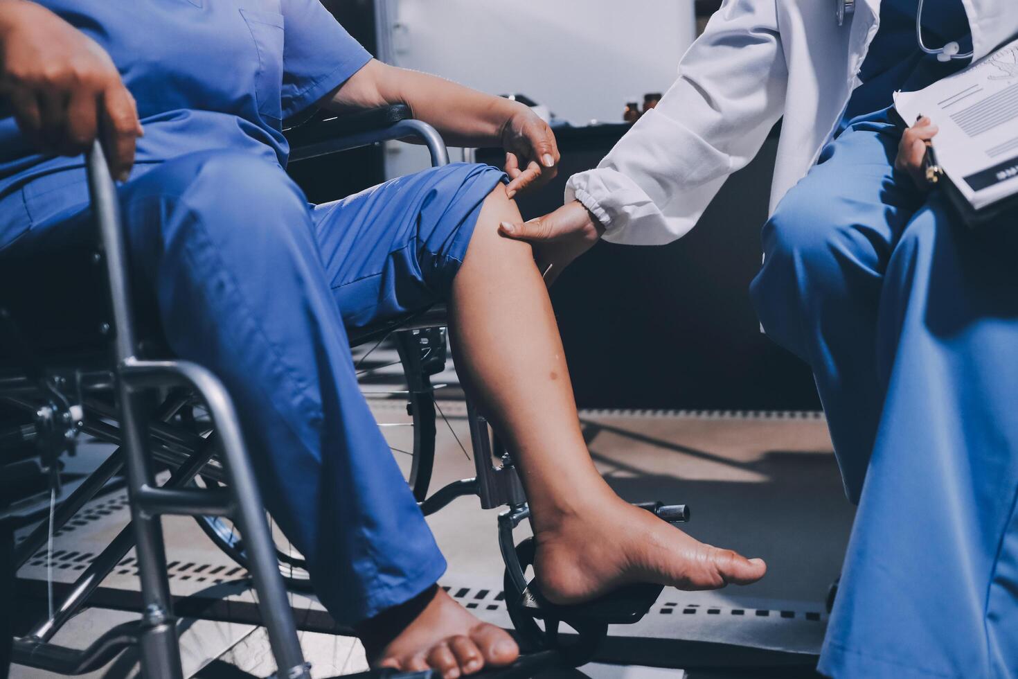 Physiotherapist nurse doing physiotherapy to rehabilitate leg of elderly female patient. photo