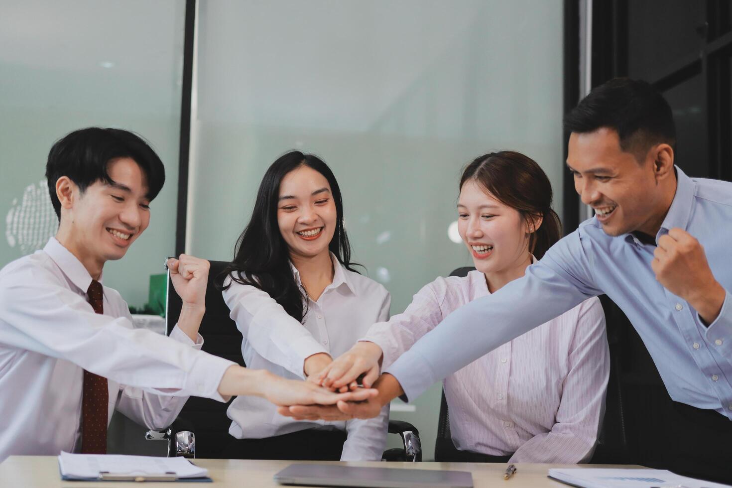 Group of business workers standing with hands together at the office photo