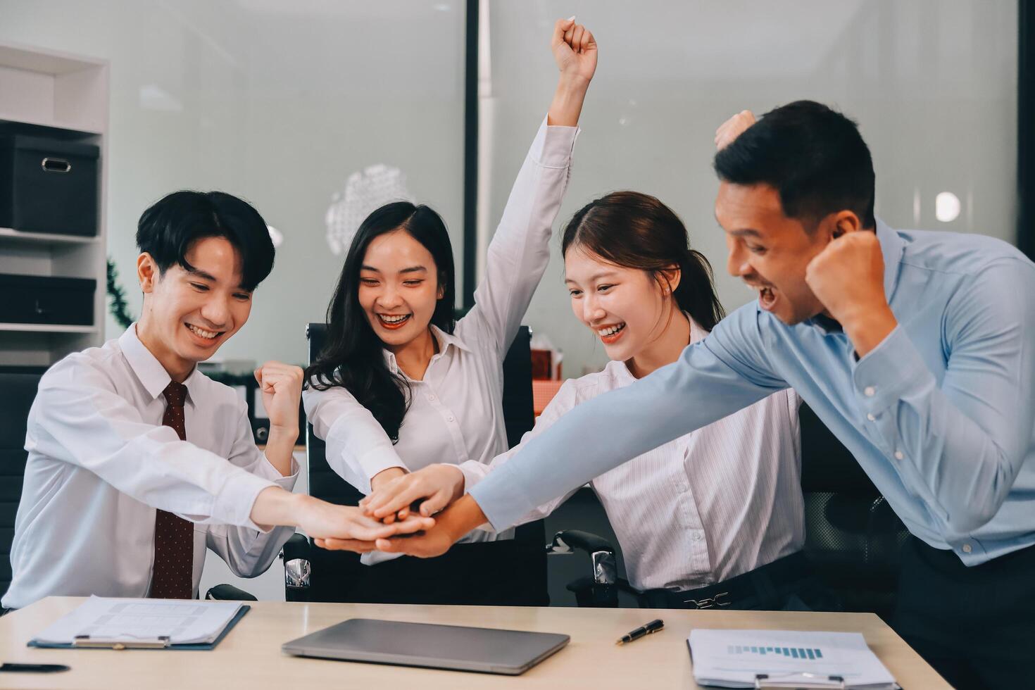 Group of business workers standing with hands together at the office photo