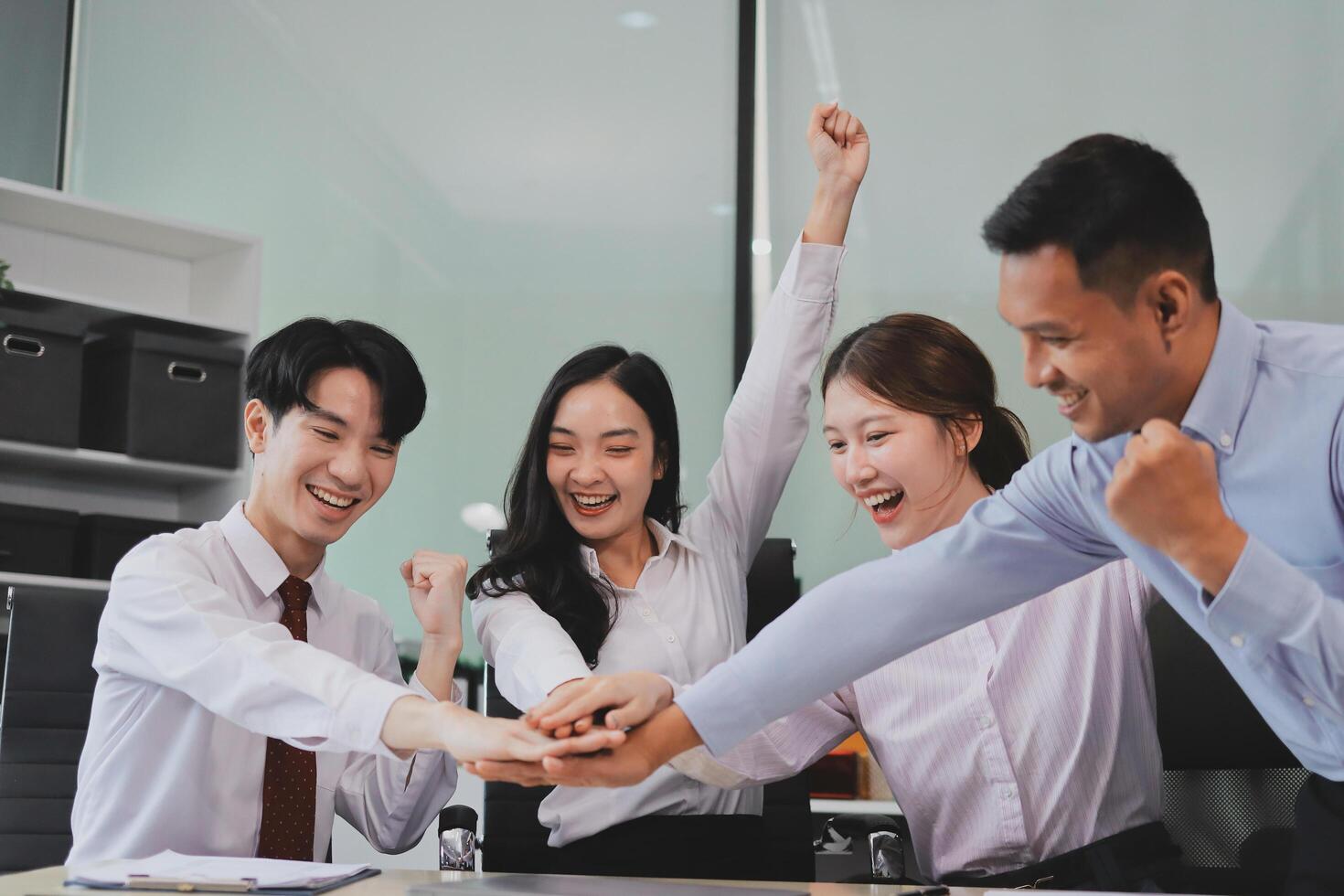 Group of business workers standing with hands together at the office photo