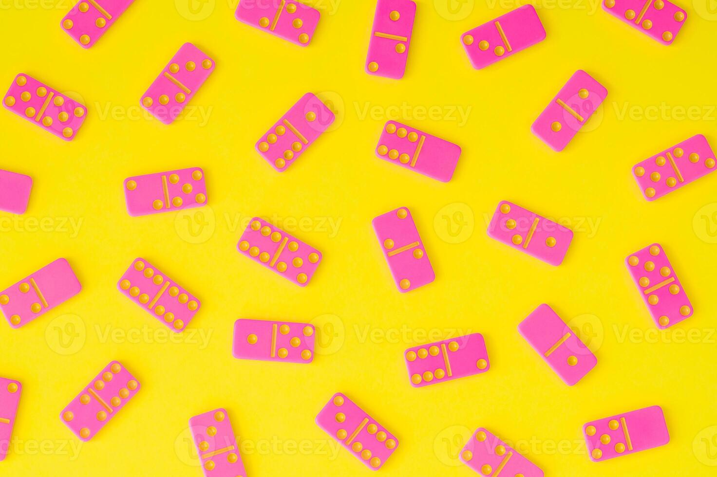 Trendy pattern made of pink dominoes on yellow background. Minimal board game concept. Creative tile based game pattern backdrop. Colorful domino flat lay idea. photo