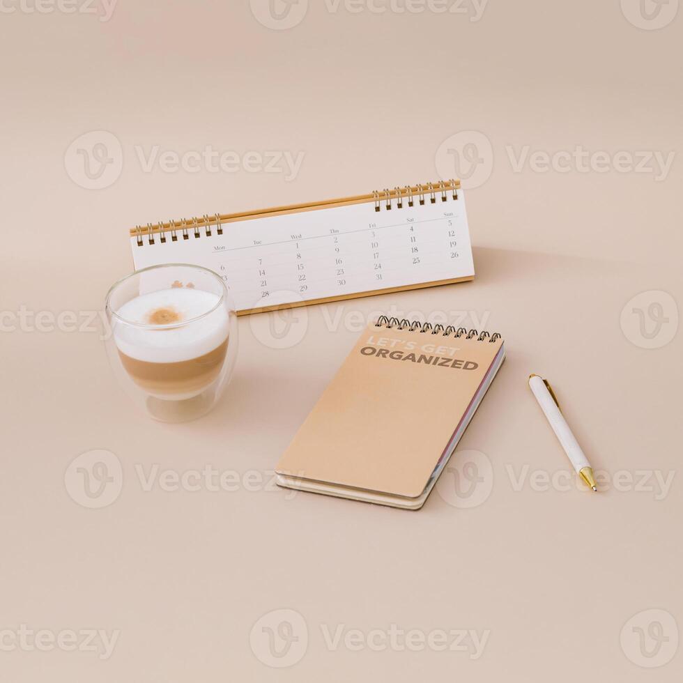 Trendy layout with calendar, planner, coffee and pen on beige background. Planner for organization and goal priorities. Writing down tasks and schedule reminders on office desk. Minimal concept. photo