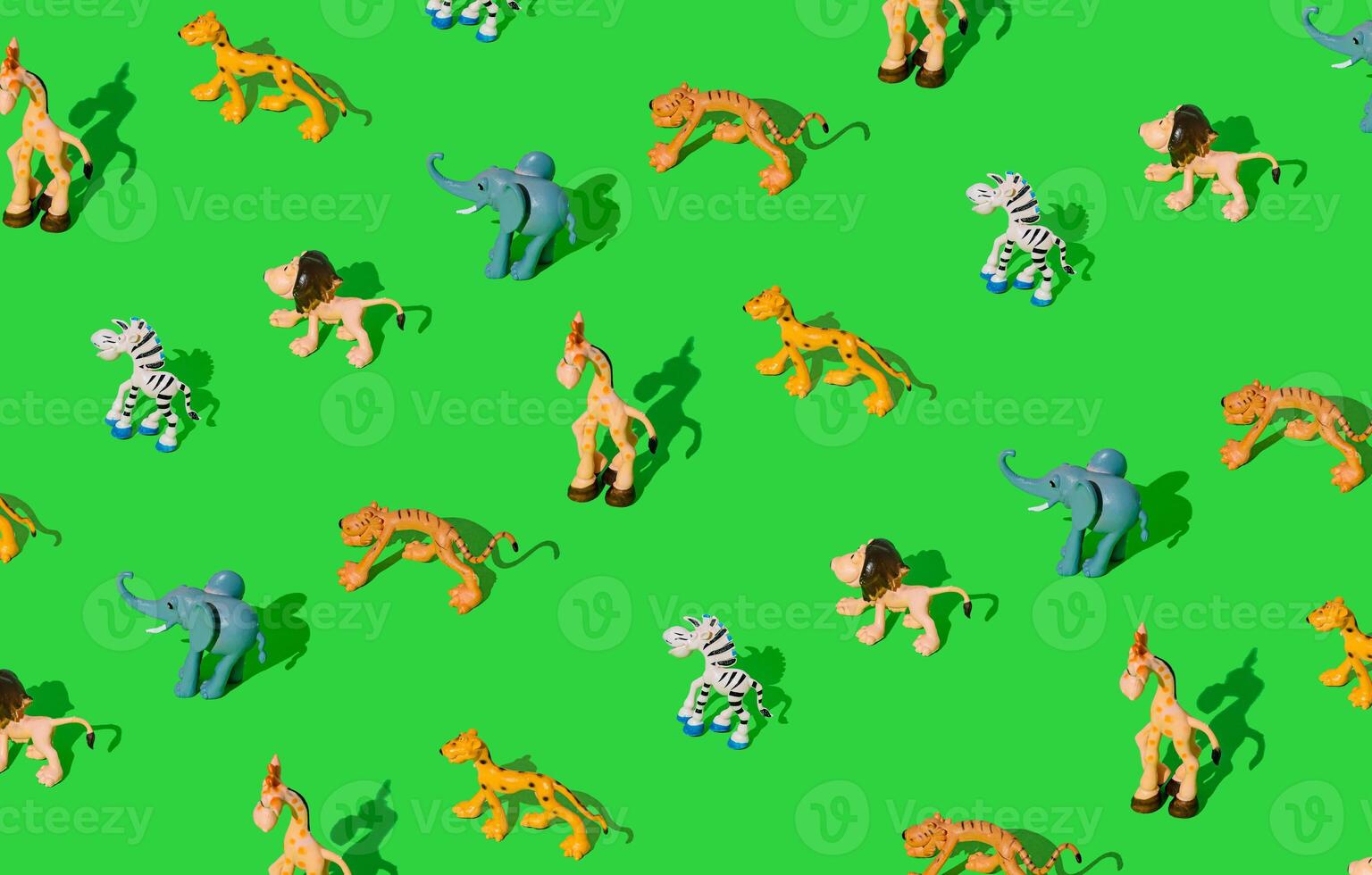 Colorful pattern made of wildlife animal toys and figurines on light green background. Minimal concept. photo