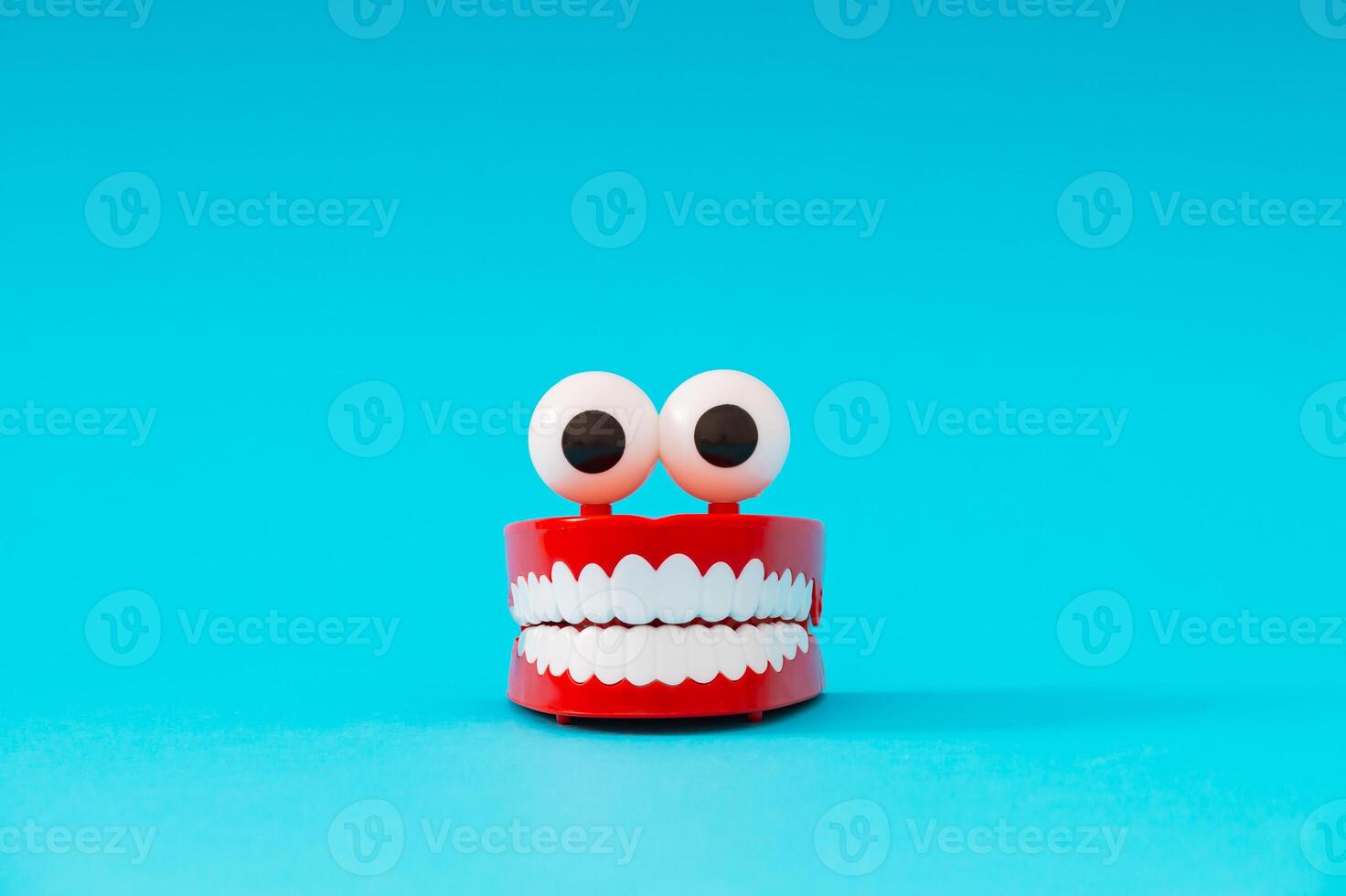 Plastic toy teeth on light blue background. Minimal abstract composition. photo