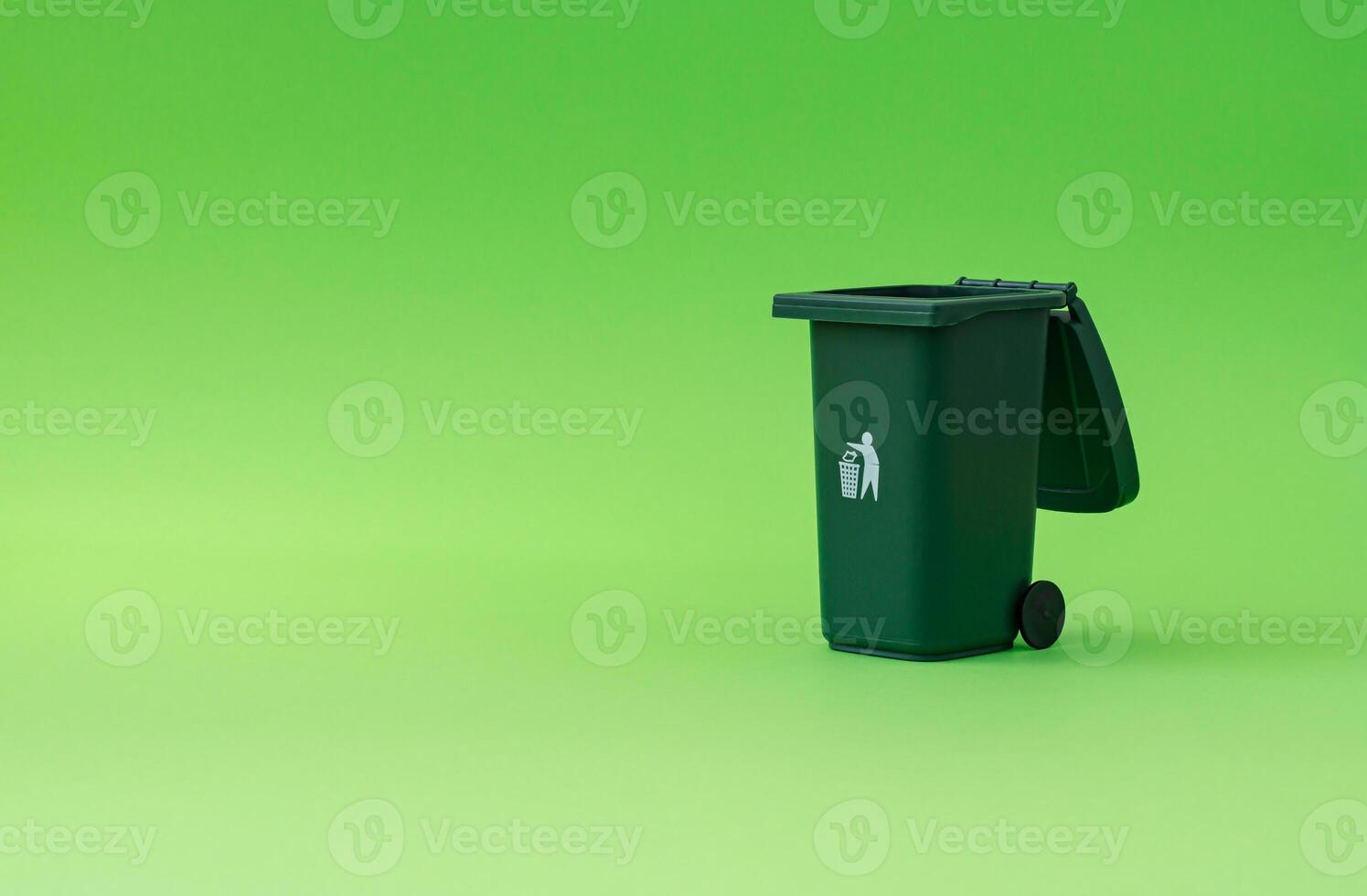 Trash recycle bin against green background. Container for disposal garbage waste and save environment. Minimal earth day concept. Green eco idea. photo
