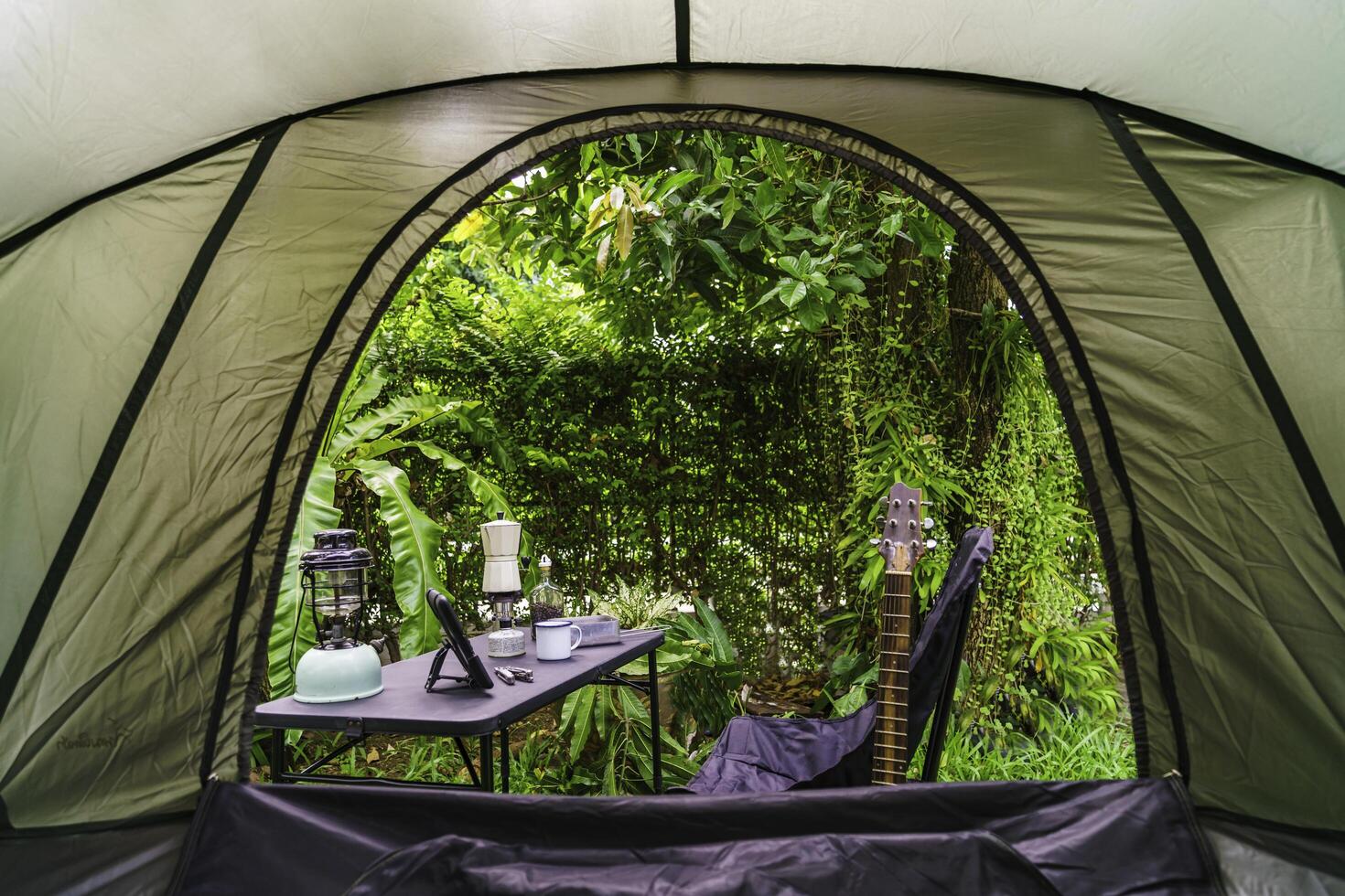 Looking out from the inside of the tent to Resting equipment for setting up a camping tent In the forest in the morning photo