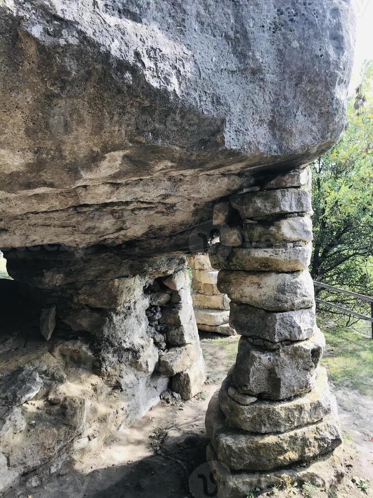 Ancient stone structure surrounded by lush greenery and sunlight photo