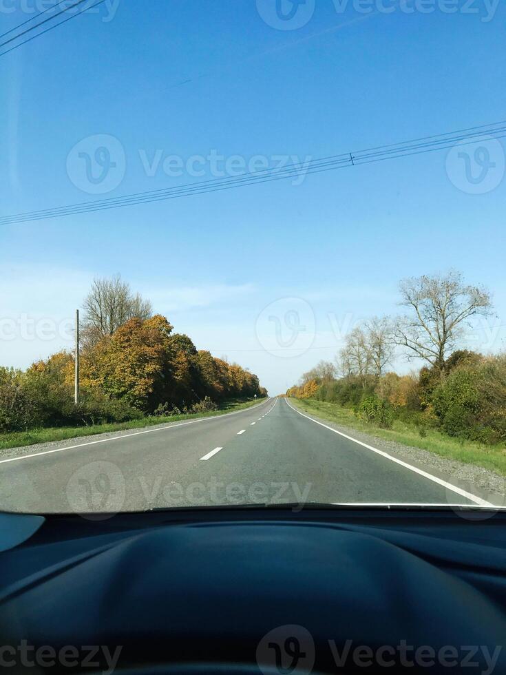 Sunny rural road view from inside car on a clear day photo