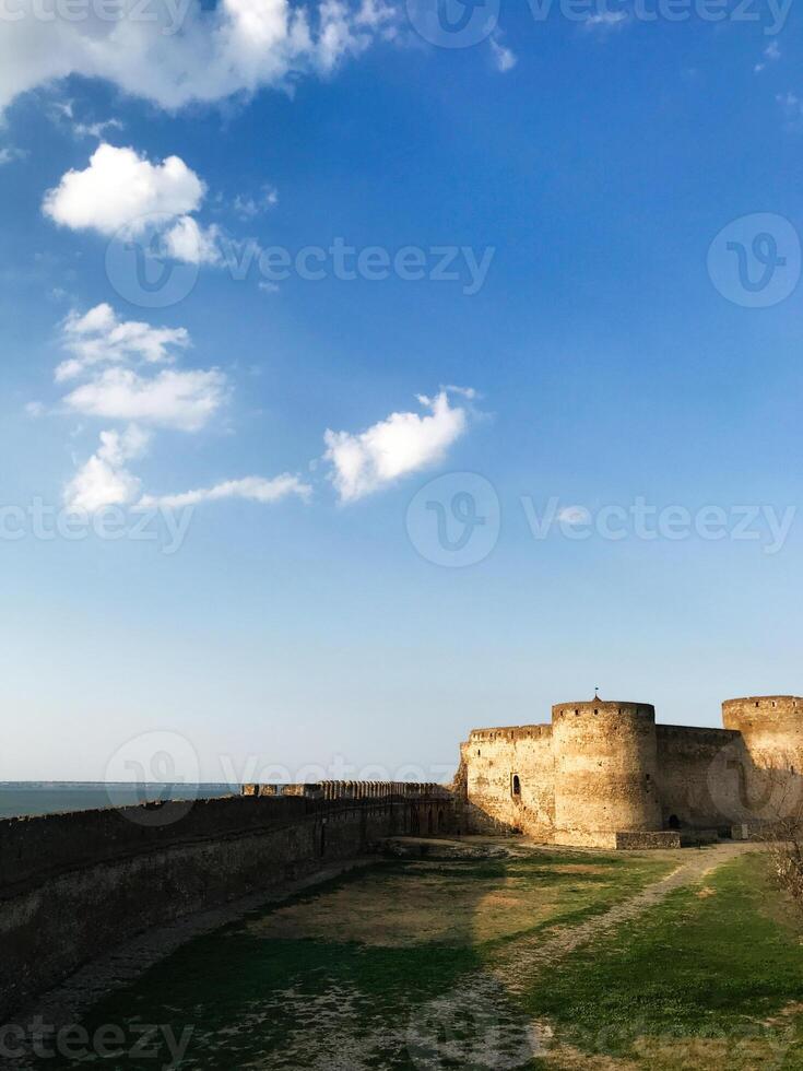Ancient stone fortress under a bright blue sky with scattered clouds. Bilhorod-Dnistrovskyi fortress, or Akkerman Kokot, Ukraine. photo