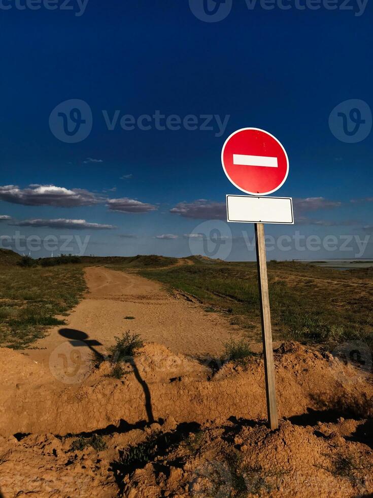 Deserted rural road with no entry road sign under blue sky photo