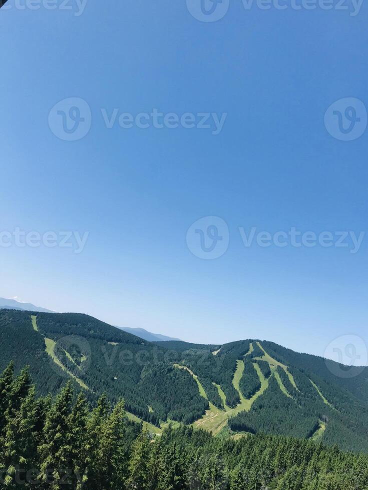 Panoramic view of lush green mountains under clear blue sky. Carpathian Mountains. photo