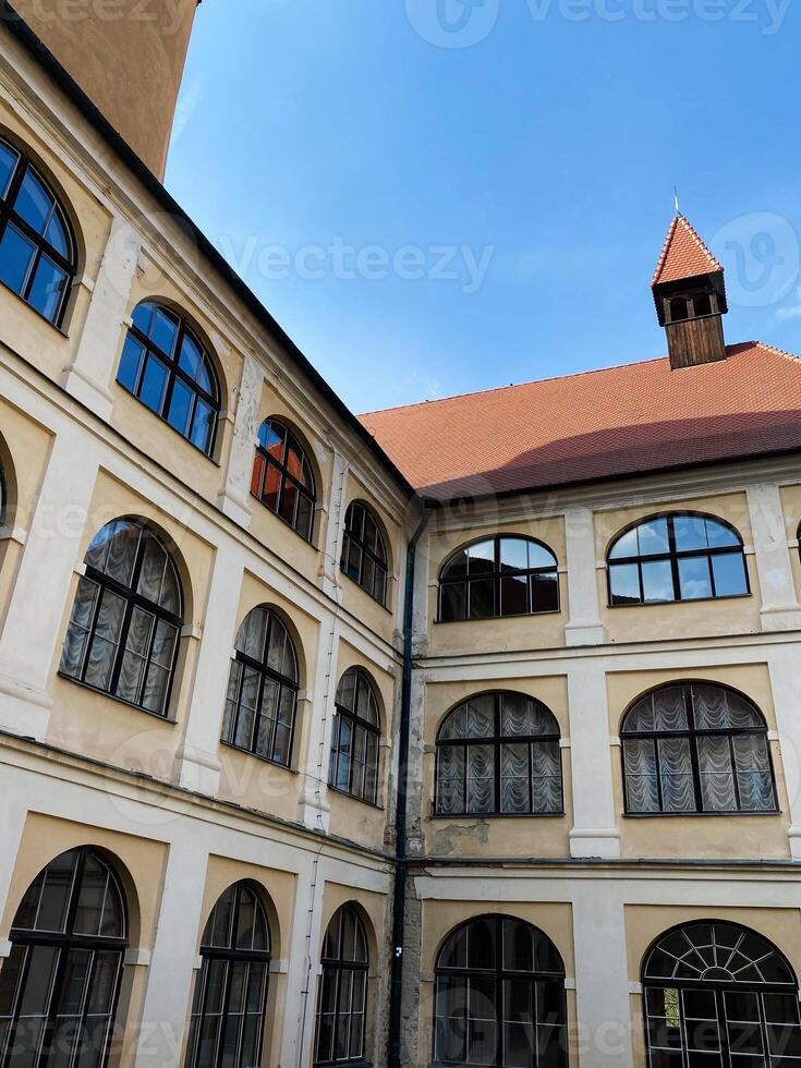 Historic building courtyard with arched windows and red roof in Veveri castle, Czech Republic. photo