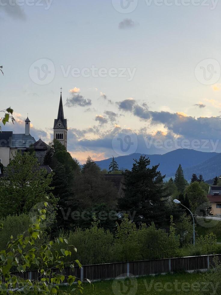 Charming village church and serene landscape at sunset in Austria photo