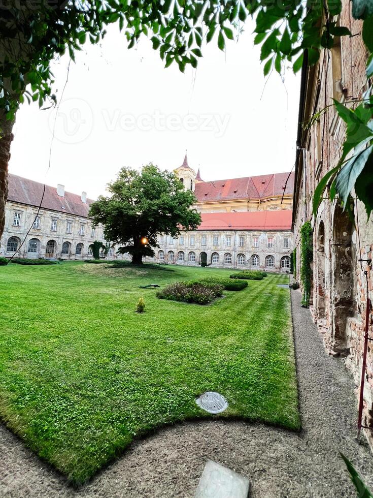 Historic courtyard with lush greenery and ancient architecture in Rajhrad, Czech Republic. photo