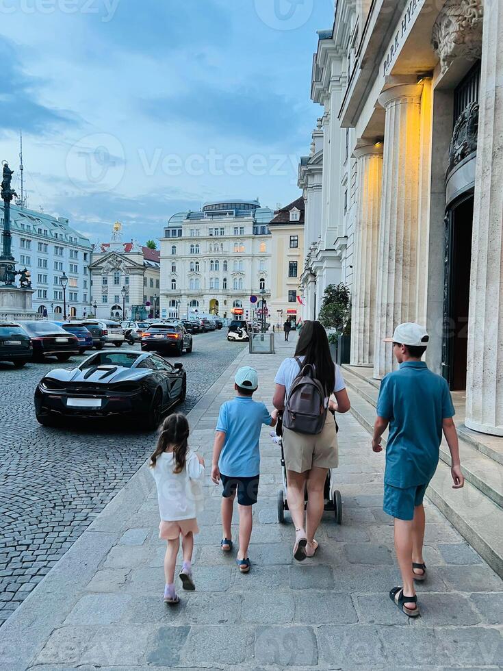 Family strolling through historic European city street at dusk in Vienna, Austria photo