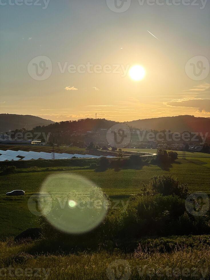 Scenic countryside field with warm sunset lighting in the sky photo