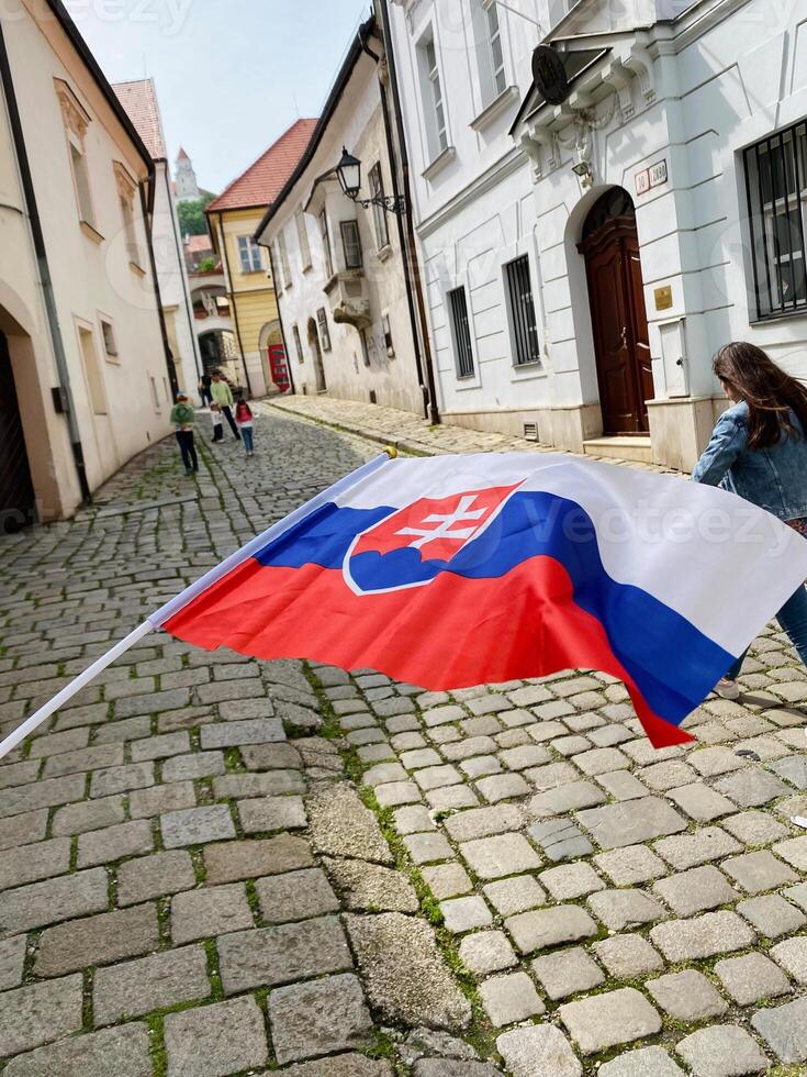 Slovakia flag waving on charming cobblestone street scene photo