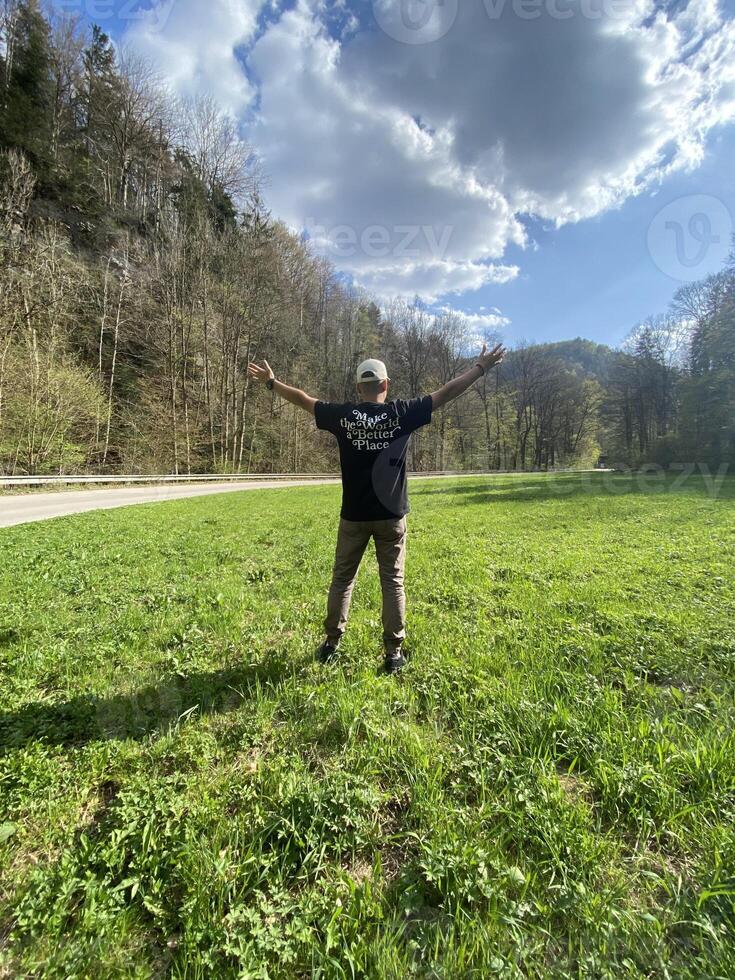 Man enjoys nature with open arms in scenic park photo