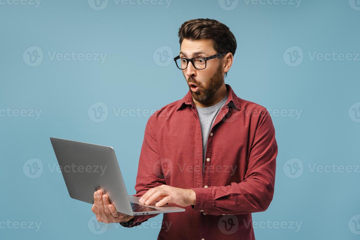 Excited, shocked Latin man, professional programmer using laptop, copywriter typing on keyboard photo