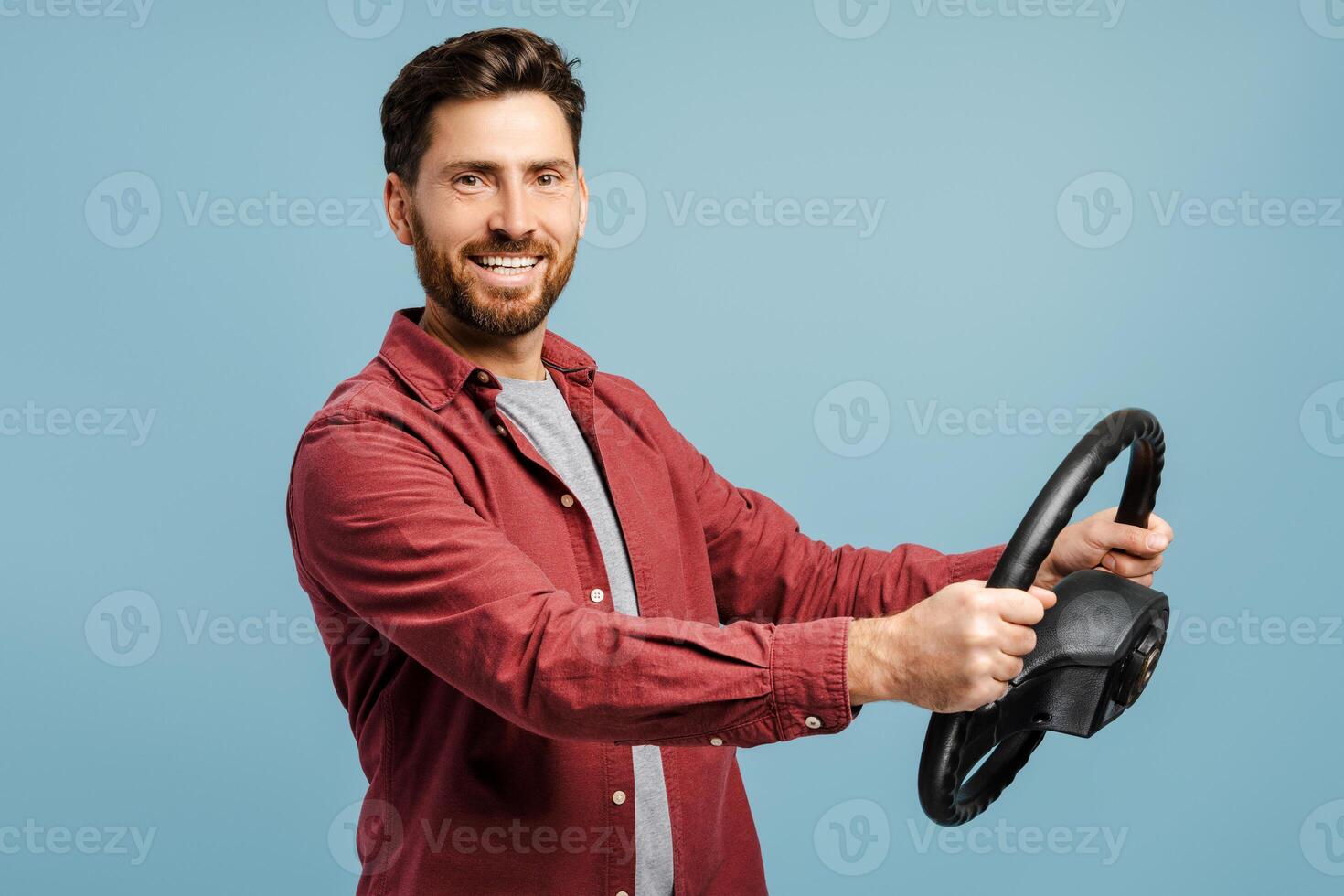 Portrait of smiling, happy bearded man holding steering wheel, looking at camera, posing photo