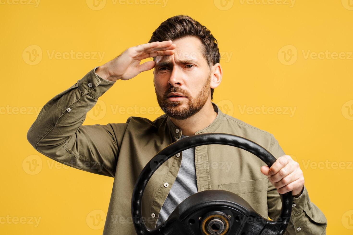 Portrait of serious, pensive bearded middle aged holding steering wheel looking away photo