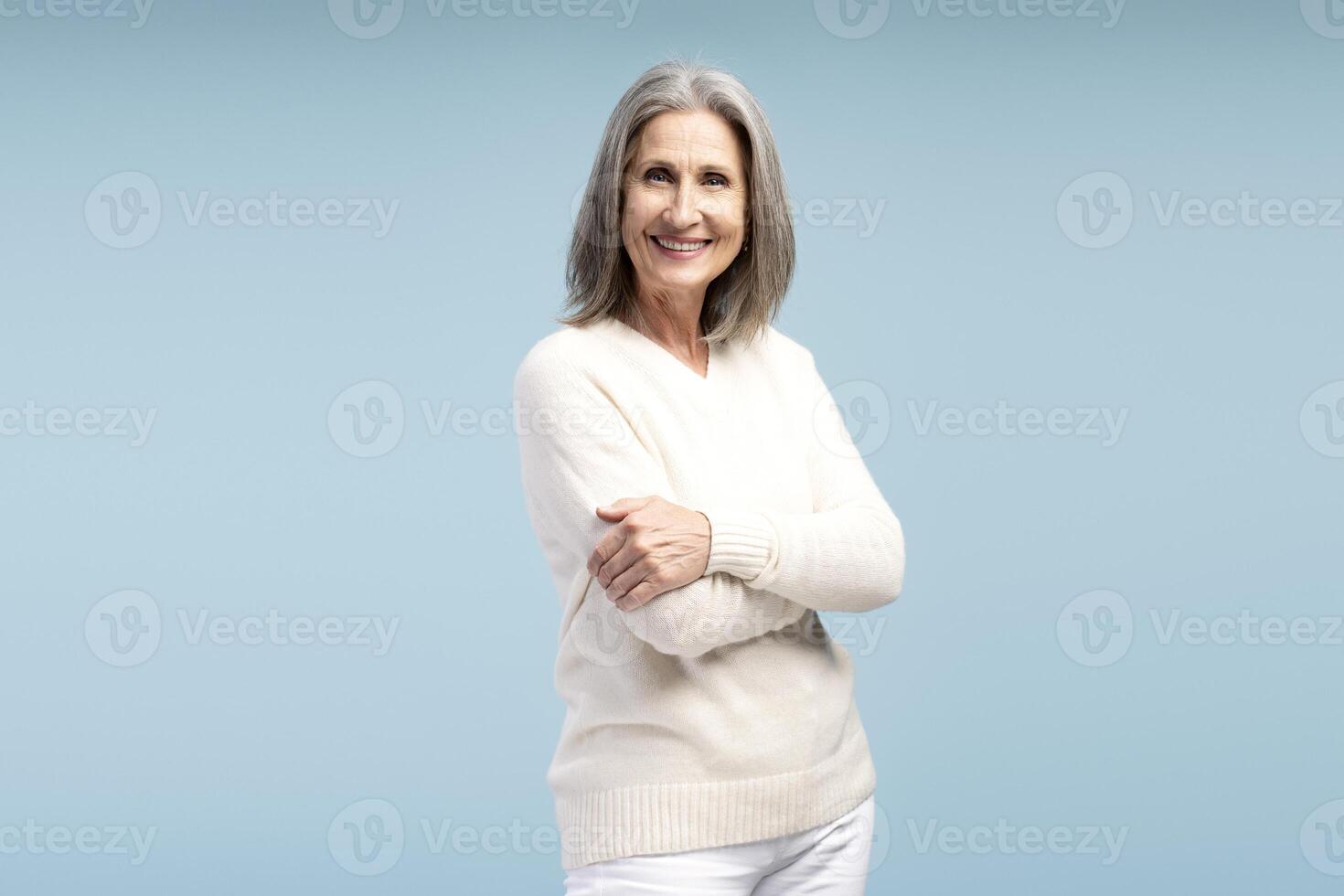 Beautiful, smiling elderly woman wearing casual clothes, elderly businesswoman with crossed arms photo