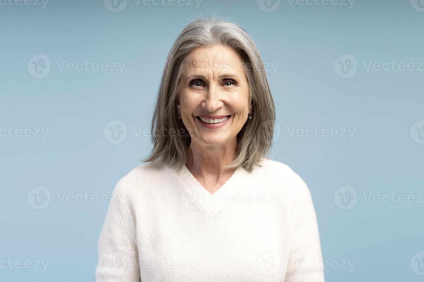 Portrait of smiling, happy senior gray haired woman wearing casual clothes looking at camera photo