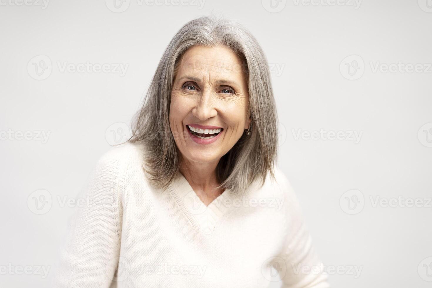 Portrait of smiling, happy gray haired, senior woman posing isolated on white background photo
