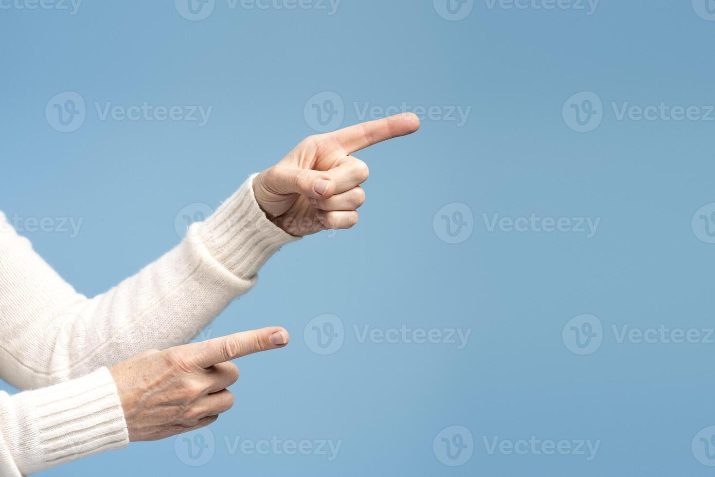 Closeup, senior woman pointing finger on copy space, selective focus on hands. Shopping concept photo