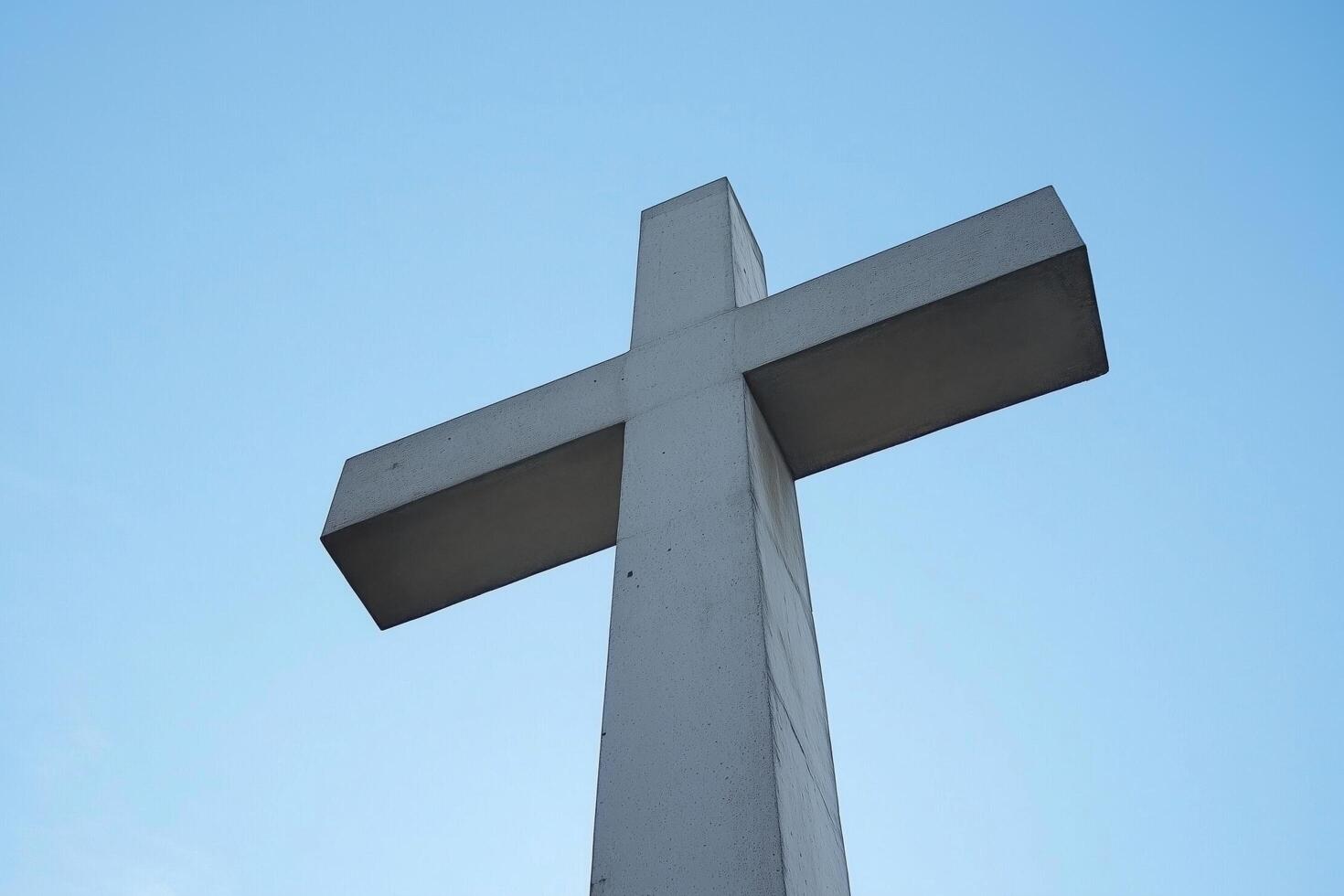 A Cross Reaching Towards the Blue Sky Emphasizing Faith and Spirituality photo