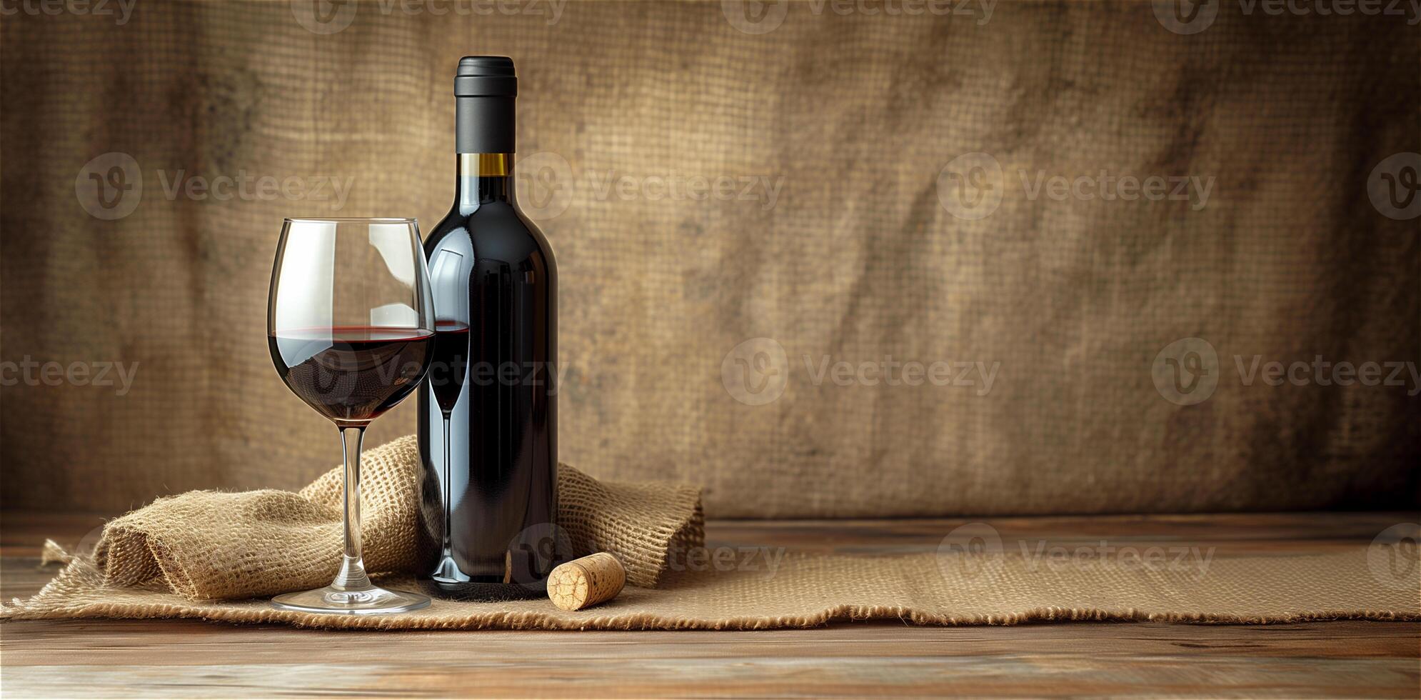 One glass with red wine and a bottle of wine on a background of undyed fabric, burlap, copy space. photo