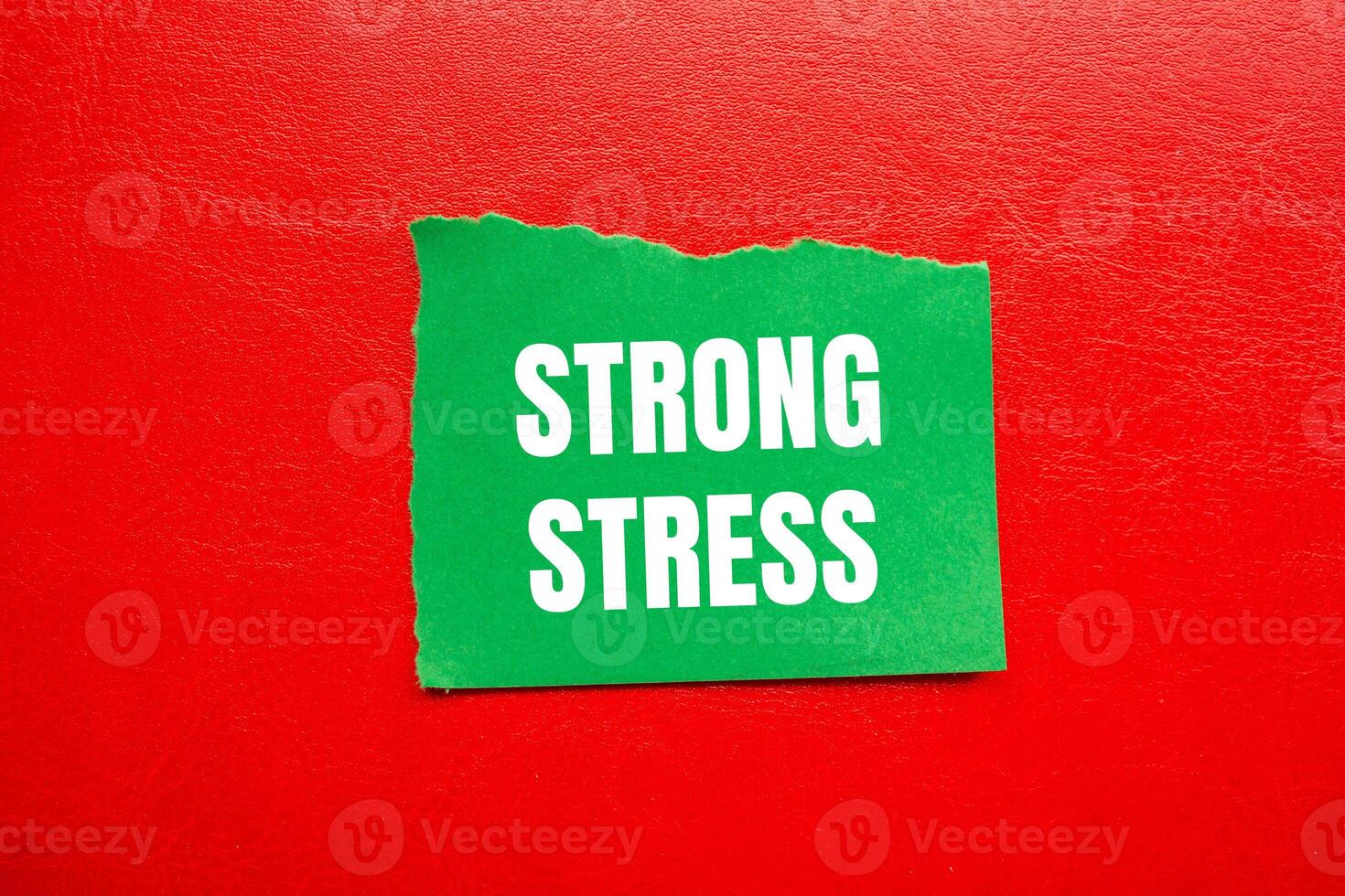Strong stress message written on ripped torn green paper piece with red background. Conceptual strong stress symbol. Copy space. photo