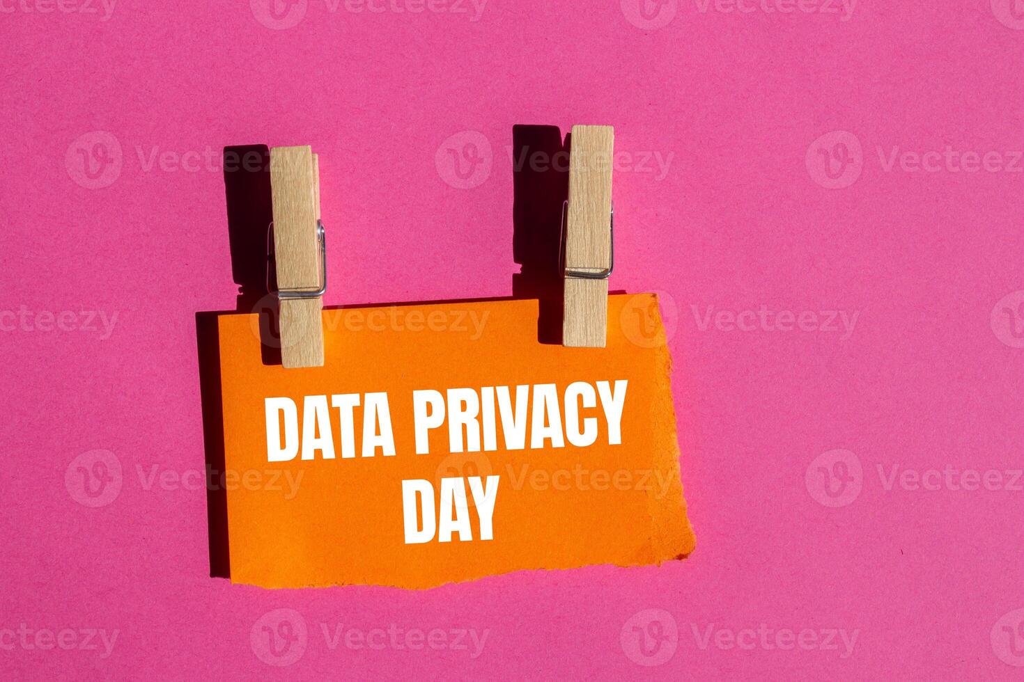 Data privacy day message written on ripped torn orange paper piece with pink background. Conceptual data privacy day symbol. Copy space. photo