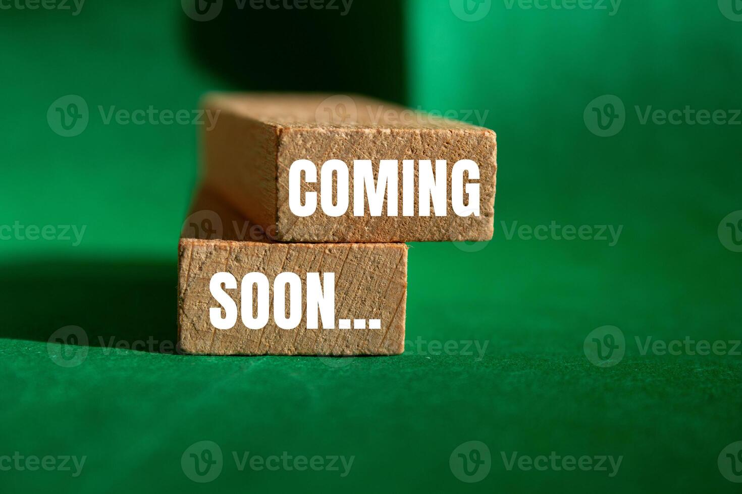 Coming soon message written on wooden blocks with green background. Conceptual coming soon symbol. Copy space. photo