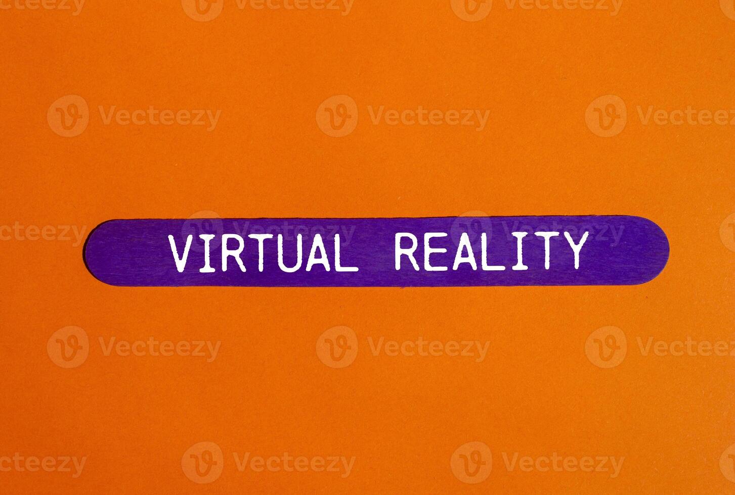 Virtual reality message written on purple wooden stick with orange background. Conceptual virtual reality symbol. Copy space. photo