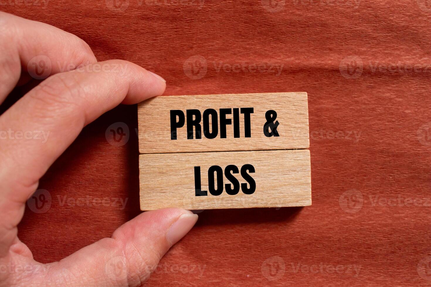 Profit and loss message written on wooden blocks with brown background. Conceptual profit and loss symbol. Copy space. photo