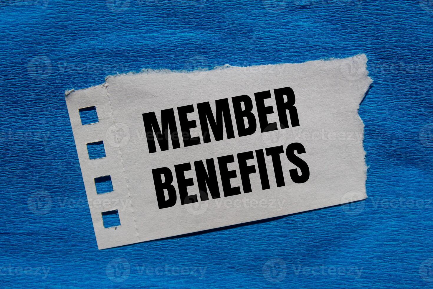 Member benefits message written on ripped torn paper piece with blue background. Conceptual member benefits symbol. Copy space. photo
