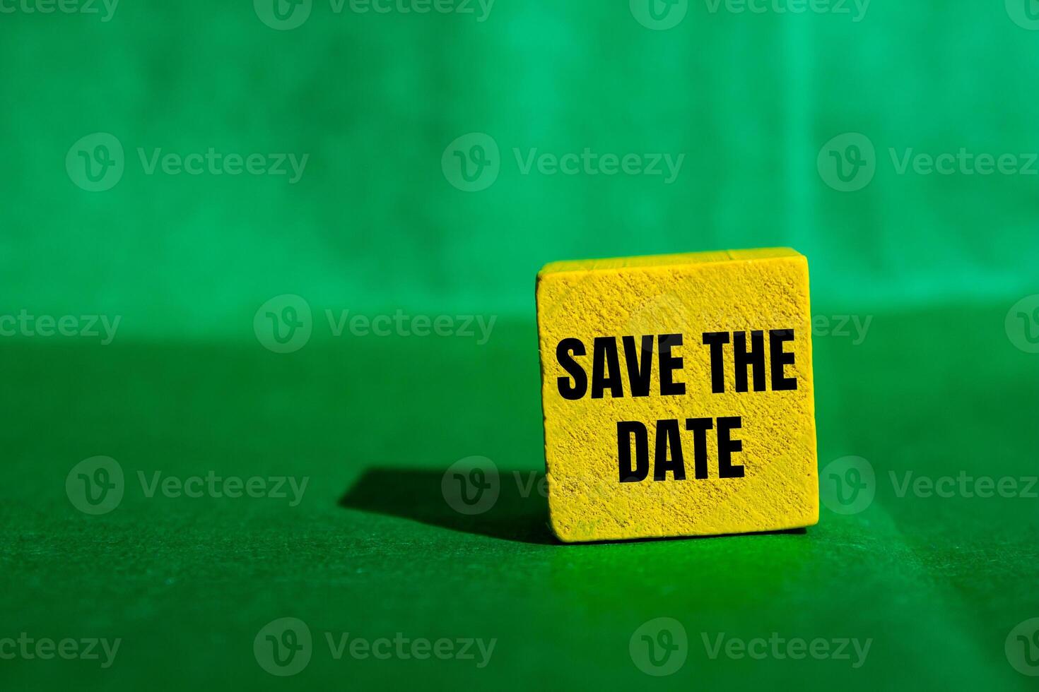 Save the date message written on yellow wooden cube with green background. Conceptual save the date symbol. Copy space. photo