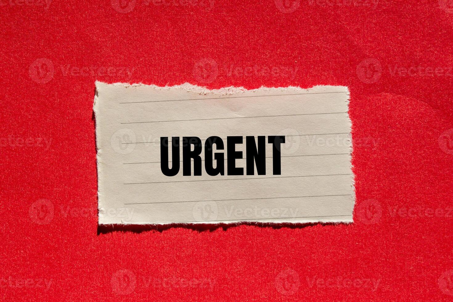 Urgent message written on ripped torn paper piece with red background. Conceptual urgent word symbol. Copy space. photo