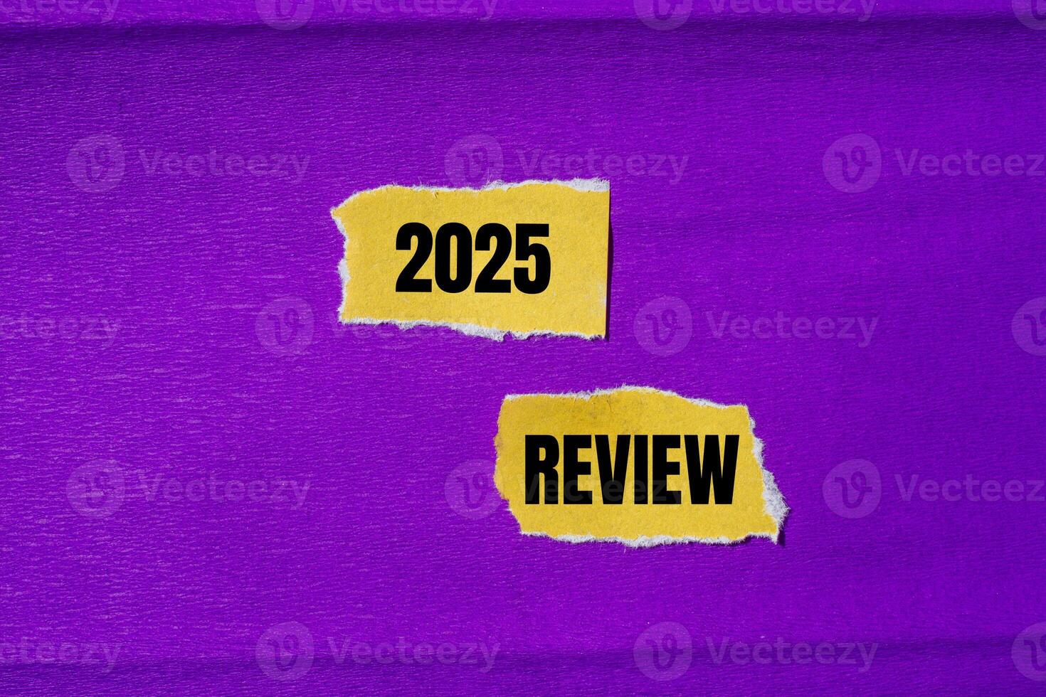 2025 review message written on ripped torn yellow paper pieces with purple background